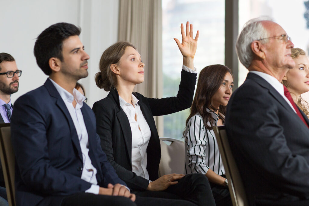 young businesswoman from audience raising hand